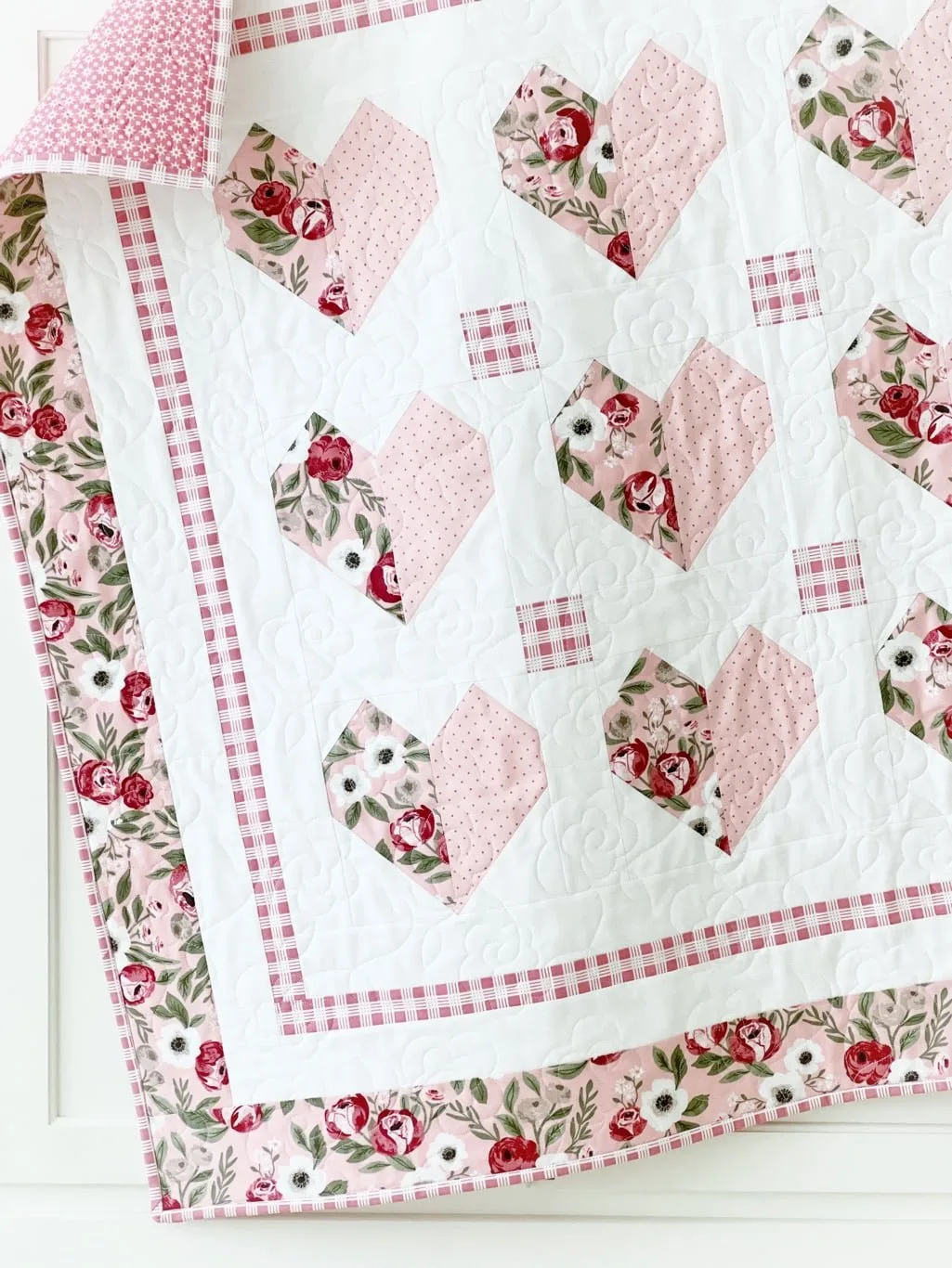 Heart To Heart quilt hanging on cabinet